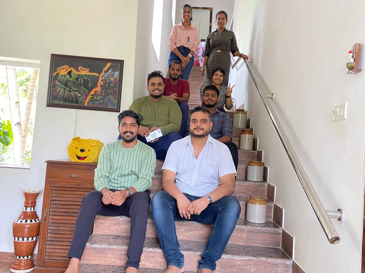 The Zunderdog team sitting together on a staircase in Goa, smiling at the camera
