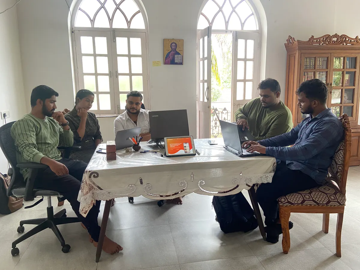 Zunderdog team members around a table with laptops and a tablet showing a website, reviewing a project